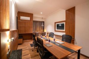 Una sala de conferencias con una gran mesa y sillas de madera. en Park Avenue Hotel Bannerghata Road, en Bangalore