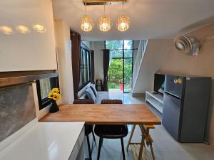 a kitchen with a table and a kitchen with a refrigerator at Srithanu Haus in Haad Chao Phao