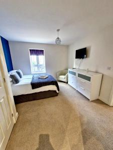 a bedroom with a bed and a television in it at Rochester Apartment in Bedford