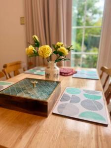 een houten tafel met daarop een gouden kruis bij Kuns house in Busheyheath