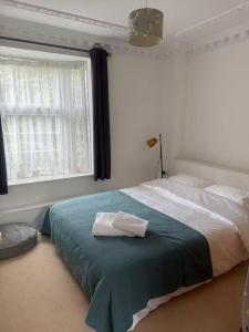 een slaapkamer met een bed met twee handdoeken erop bij Kuns house in Busheyheath