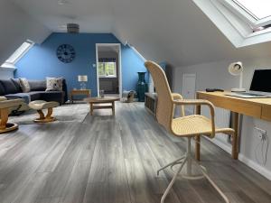 a living room with blue walls and a desk and chairs at The Barn at Hydestile Stud in Milford