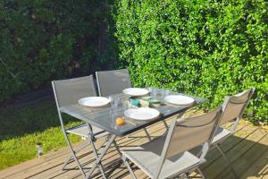 a glass table with four chairs on a patio at Nid confort proche du canal du midi 2 terrasses Labège in Labège +22 photos