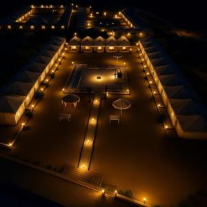una vista aerea di un edificio con ombrelli di notte di Dunes Heritage Desert Camp a Jaisalmer Altre 4 foto