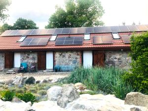 a house with solar panels on the roof at Siedlisko Żywe Kamienie in Naguszewo