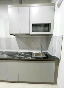 a white kitchen with a sink and a microwave at Tâm Anh Hotel in Hanoi