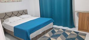 a bedroom with a bed with a blue curtain at Pieds dans l'eau in Goodlands