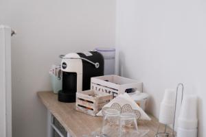 eine Theke mit Kaffeemaschine und Gläsern darauf in der Unterkunft Kosmosuite in Brindisi