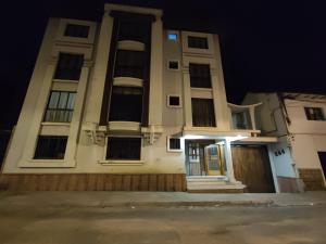 a large white building with a door at night at Sucre Serenity Home in Sucre