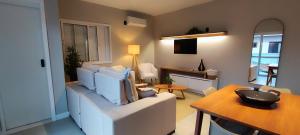 a living room with a white couch and a table at Casa Californiana Pousada in Garopaba
