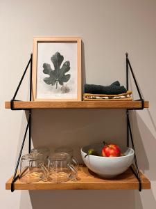 a shelf with a bowl of fruit and a picture at Logeerkamer Water op Buitenplaats de Burgwal in Leusden