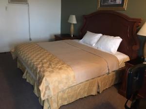 Habitación de hotel con cama grande con almohadas blancas en Sunset Inn, en Atlantic City