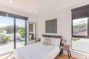 a white bedroom with a bed and a large window at Modern Design District Wynwood TH wHeated Pool in Miami +49 photos