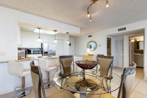 une cuisine et une salle à manger avec une table et des chaises en verre dans l'établissement Dolphin Point, à Destin
