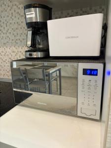 a microwave sitting on top of a counter at The Bright Bridge, Near Sliema with AC in Il-Gżira +11 photos