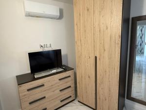 a wooden cabinet with a television on top of it at Holiday Home - Si Do Relais in Pozzuoli