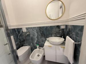 a bathroom with a sink and a toilet and a mirror at Holiday Home - Si Do Relais in Pozzuoli +23 photos