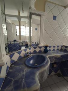 a blue and white bathroom with a sink and a mirror at Sucre serenity Home in Sucre +26 photos