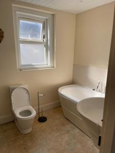 a bathroom with a tub and a toilet and a sink at 6 Bedroom PLYMOUTH in Moffat