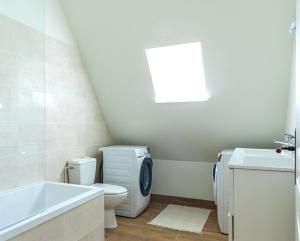 a bathroom with a toilet and a sink and a bath tub at Aux Roses et aux Poutres - Jardin - Arrivée Autonome in Le Tremblay-le-Vicomte +25 photos