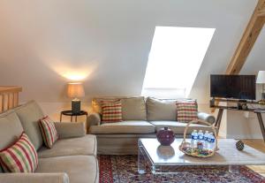 a living room with a couch and a table at Aux Roses et aux Poutres - Jardin - Arrivée Autonome in Le Tremblay-le-Vicomte