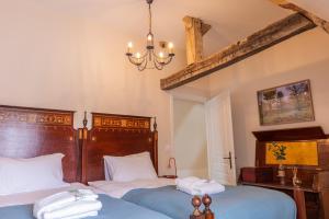 a bedroom with two beds and a chandelier at Aux Roses et aux Poutres - Jardin - Arrivée Autonome in Le Tremblay-le-Vicomte