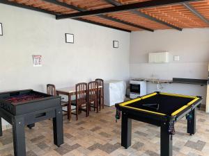 a living room with two ping pong tables and a kitchen at Linda Casa com piscina Aquecida e área de lazer in Caldas Novas
