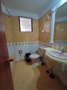 a bathroom with a sink and a toilet and a window at Sucre Serenity home in Sucre