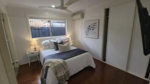 a small bedroom with a bed and a window at Seffa Dom property Melbourne in Springvale South +20 photos