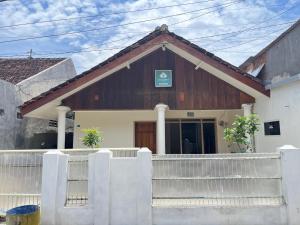 a house with a wooden roof and a fence at 55 Ketapang Homestay in Ketapang