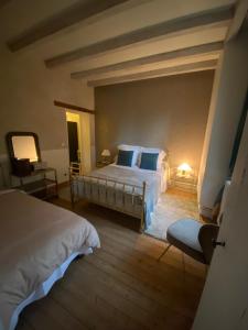 a large bedroom with two beds and a lamp at Grandes Molaises in Les Hogues