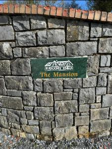 a sign on the wall of a brick wall at The Mansion in Ballintober