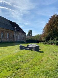 two couches sitting in a field in front of a building at Grandes Molaises in Les Hogues