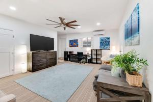 a living room with a couch and a flat screen tv at Pompano Beach Hideaway with Fenced Yard & BBQ in Pompano Beach