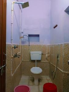a bathroom with a toilet and a shower at Kanchan Lata Homestay in Banāras Cantonment
