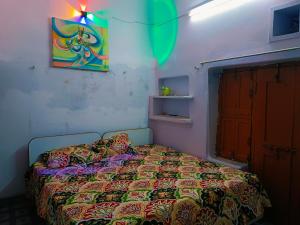 a bedroom with a bed and a painting on the wall at Kanchan Lata Homestay in Banāras Cantonment