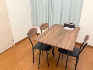 a wooden table with four chairs in a room at 宿泊処 杜輝 in Oshima