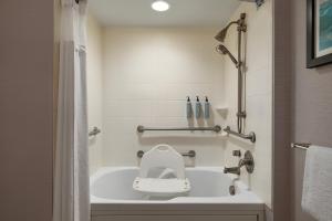 a bathroom with a tub with a toilet in it at Courtyard by Marriott Ocean City Oceanfront in Ocean City