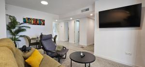 a living room with a couch and a tv on a wall at Apartment Oceana - Luxury Sea View Beach Apartment in Calpe