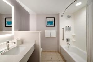 a white bathroom with a tub and a sink at Courtyard by Marriott Ocean City Oceanfront in Ocean City