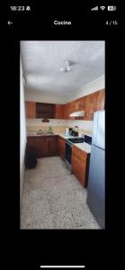 a kitchen with wooden cabinets and a white refrigerator at Amplio apartamento, Excelente ubicación 3 habitaciones 5 camas in Coatzacoalcos +9 photos