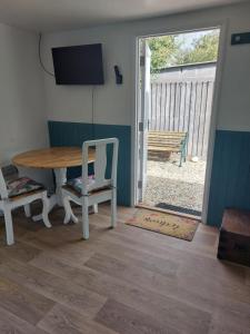 ein Esszimmer mit einem Tisch und Stühlen sowie einer Schiebetür in der Unterkunft The Garden Room at Poplar Cottage in Wick Saint Lawrence + 3 Fotos