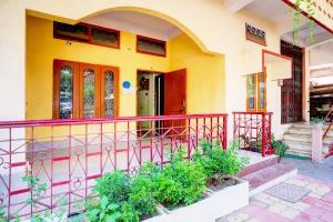 a yellow and red house with a red railing at Hotel O Modern Home in Guwahati