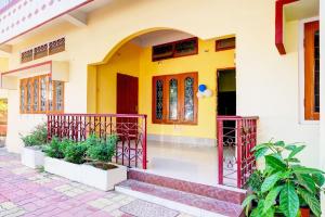 a yellow house with a staircase in front of it at Hotel O Modern Home in Guwahati