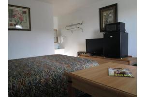 ローズバーグにあるHotel O Motel 10 Lordsburg I-10のベッドとテレビがあるホテルの部屋