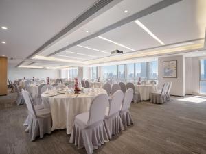 a banquet hall with white tables and chairs and windows at Holiday Inn Express Wuxi Taihu by IHG in Wuxi