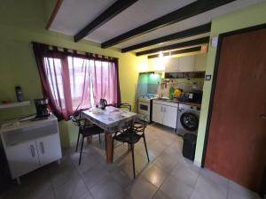 Una cocina con una mesa y sillas en una habitación. en Valentyna Aparts El Chalten 4, en El Chaltén 57 fotos más