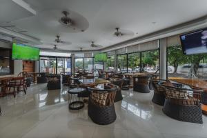a restaurant with tables and chairs and windows at Hotel Plaza Kokai Cancún in Cancún