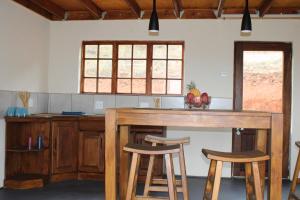 una cucina con tavolo in legno e 2 sgabelli di Oppiberg Cottage with River View a Hartbeespoort