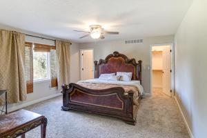 Un dormitorio con una cama grande y un ventilador de techo. en Des Moines Suburb Stay with Spacious Layout and Deck!, en Johnston